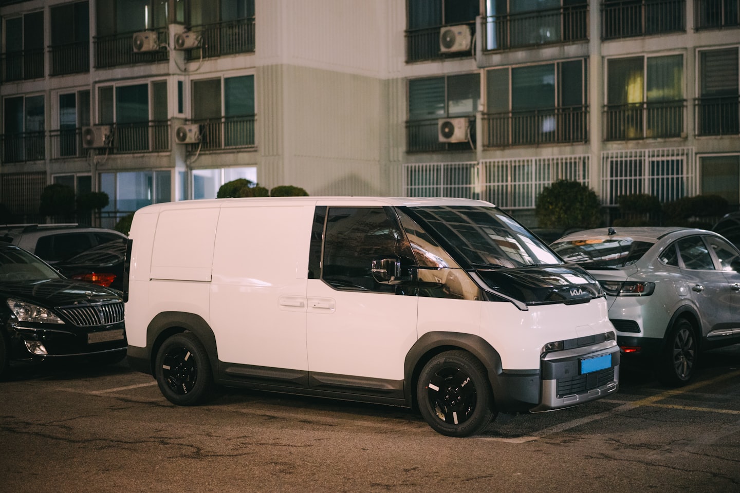 A white delivery van parked in an urban parking lot.